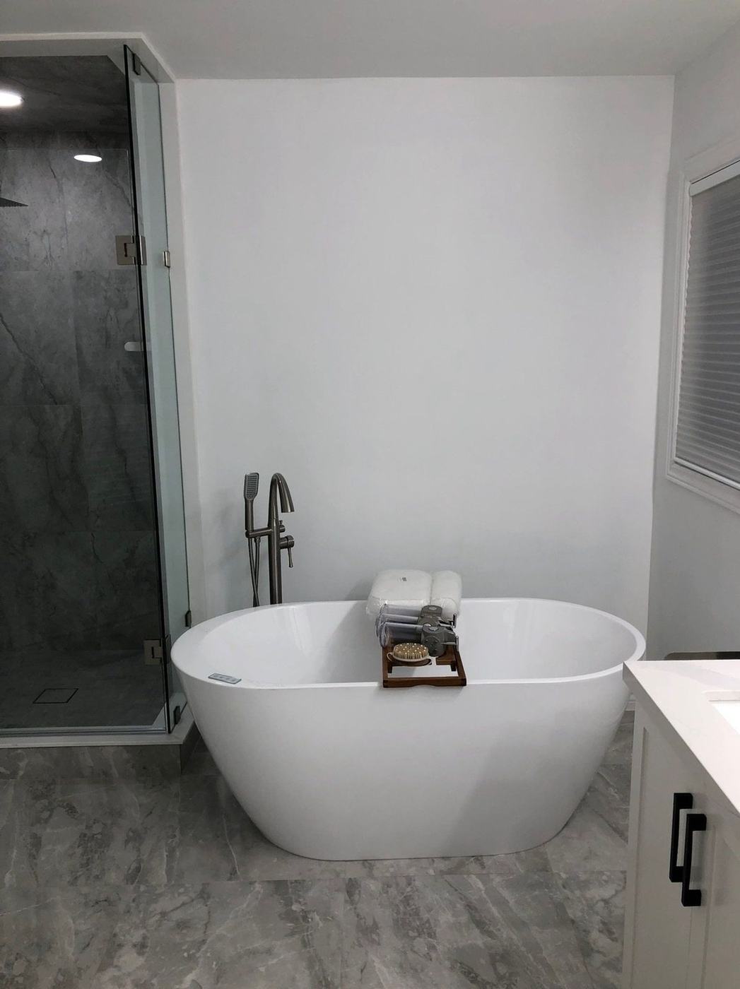 Bathroom with a freestanding tub beside a glass steam shower and large-format tile in Thornhill, by NewGen Renovations Vaughan